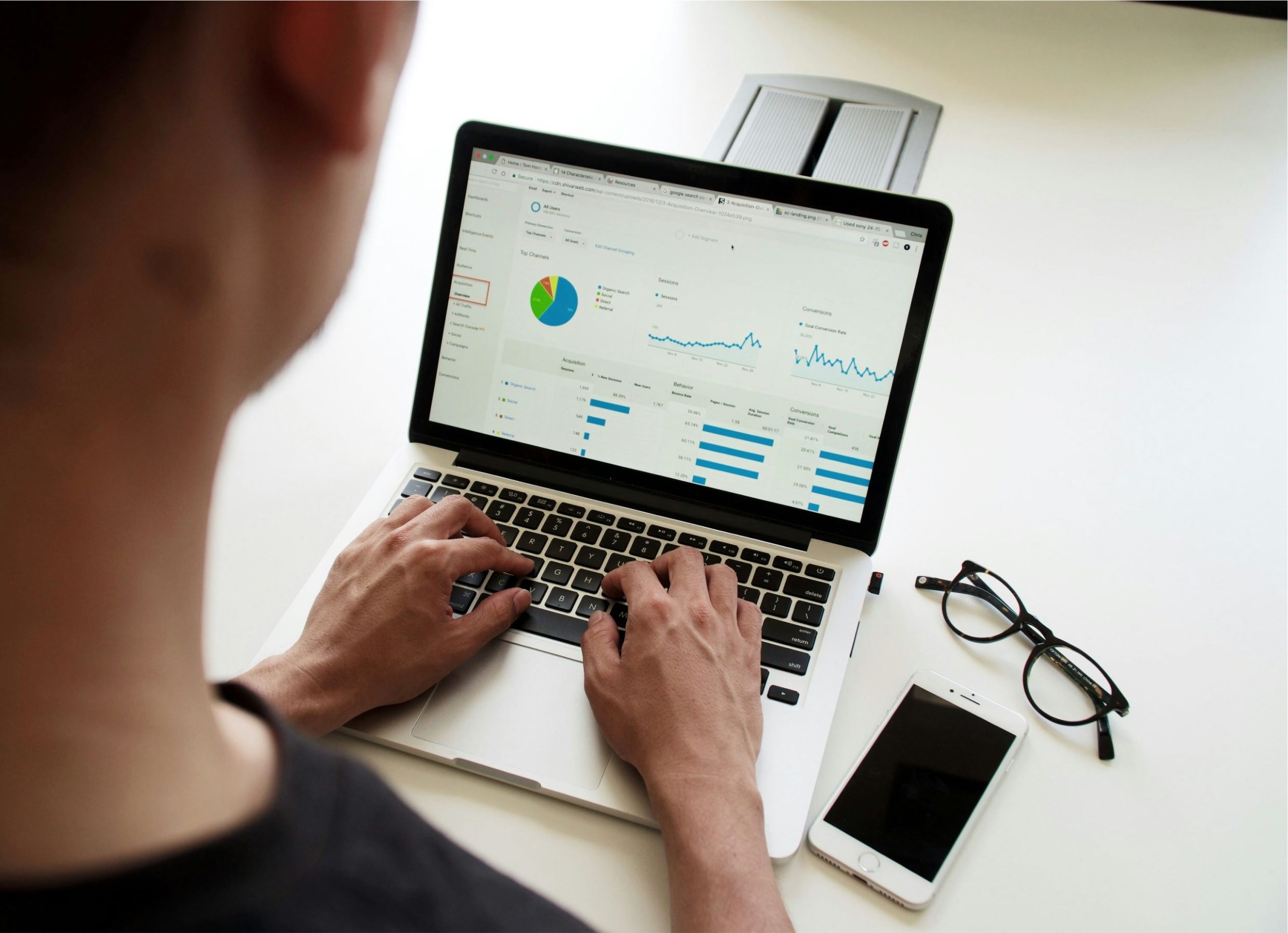 Pessoa analisando dados sobre fluxo de caixa em um laptop, com gráficos e estatísticas na tela.