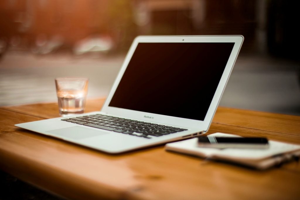 Imagem de um laptop sobre uma mesa de madeira, representando o mundo das fintechs com inteligência artificial.