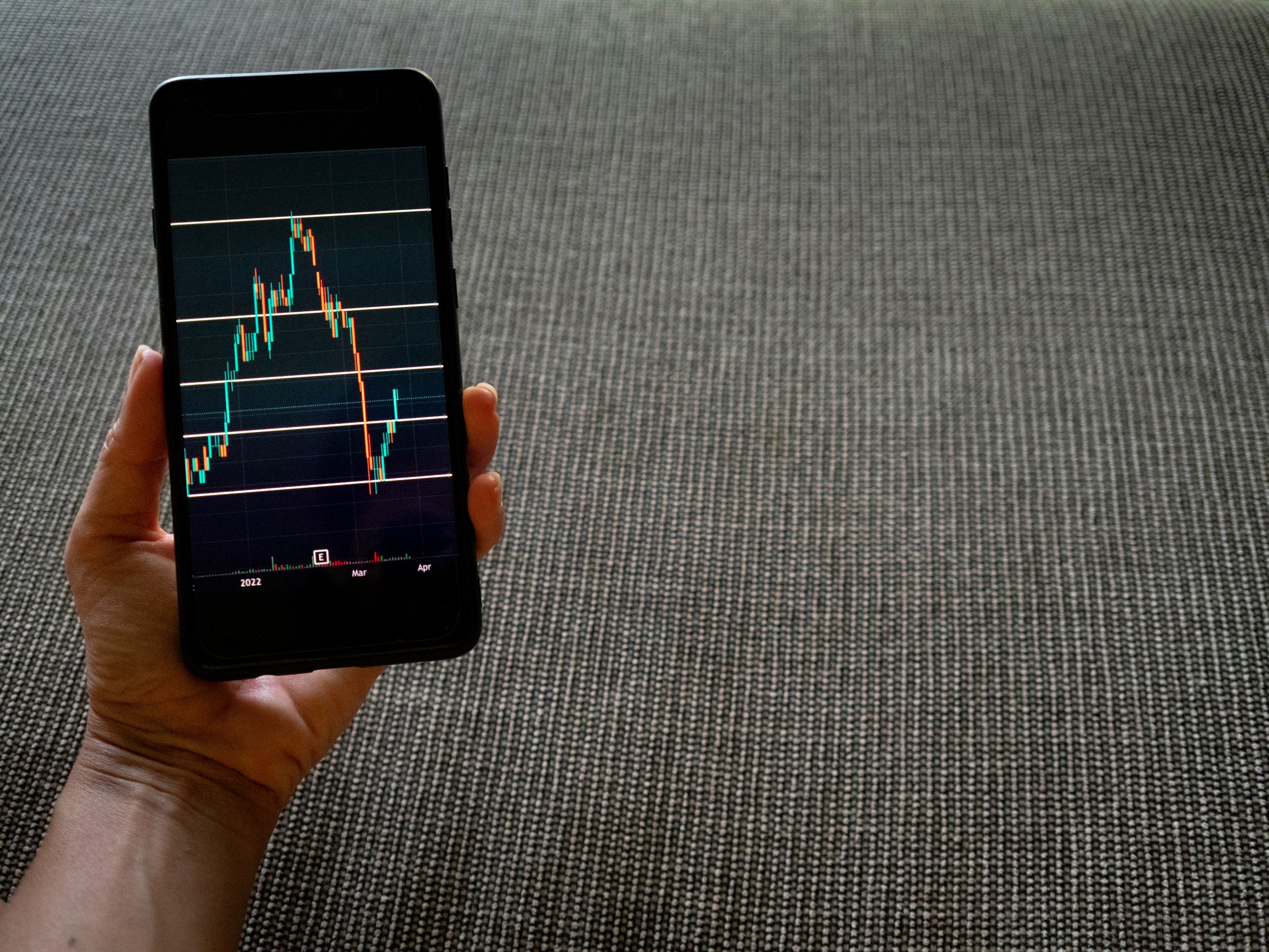 Imagem mostrando um smartphone exibindo um gráfico financeiro, representando sucessão patrimonial.